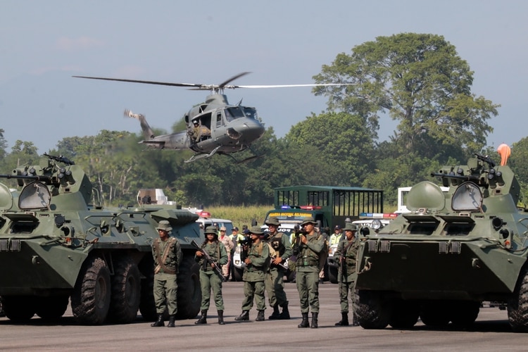 Dos BTR-80A y un helicóptero de la familia Bell 412 (Schneyder MENDOZA / AFP)
